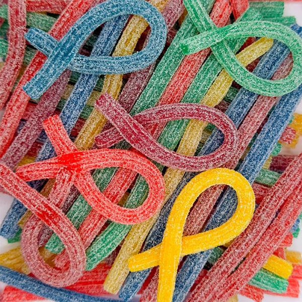 Close-up of sour straw candy strips showing colorful coating and texture